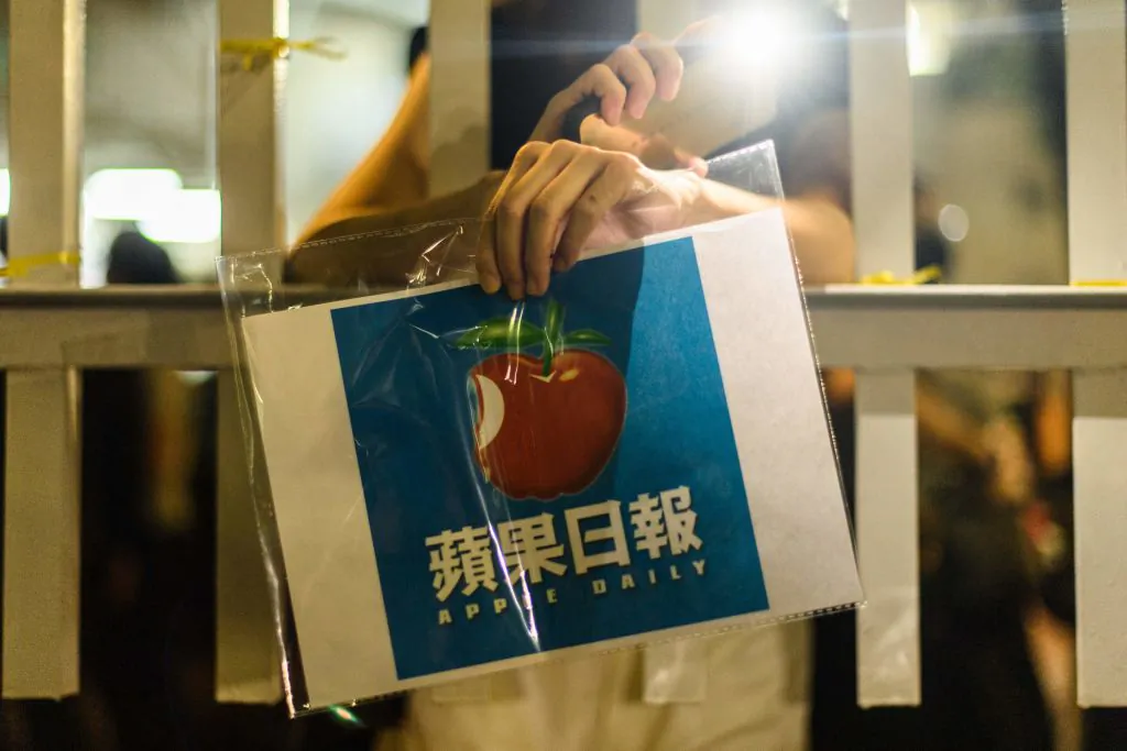 A supporter holds a poster of the Apple Daily newspaper logo outside the media company's office building in Hong Kong in the early hours of June 24, 2021, shortly after the 26 year old newspaper went to print for the last time. (Anthony Wallace/AFP via Getty Images)