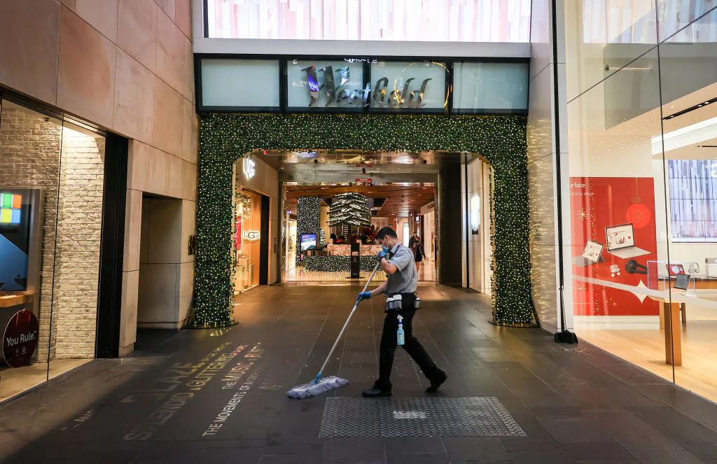 A cleaner works outside the entrance to the Westfield shopping centre during the Boxing Day sales on Dec. 26, 2020, in Sydney, Australia. (David Gray/Getty Images)