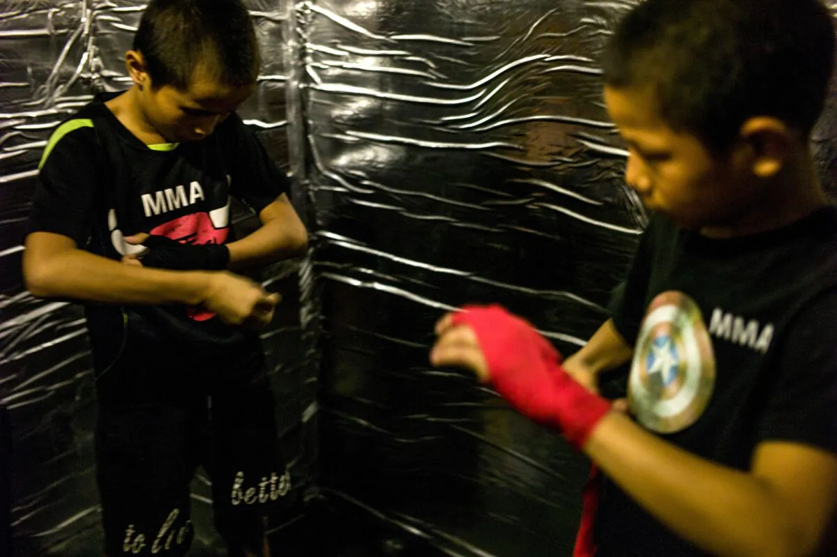 Jihushuojie (R), 12, and Abieamu, 13, preparing for a fight in an underground fight club in Chengdu, China, on June 2, 2017. (Fred Dufour/AFP via Getty Images)