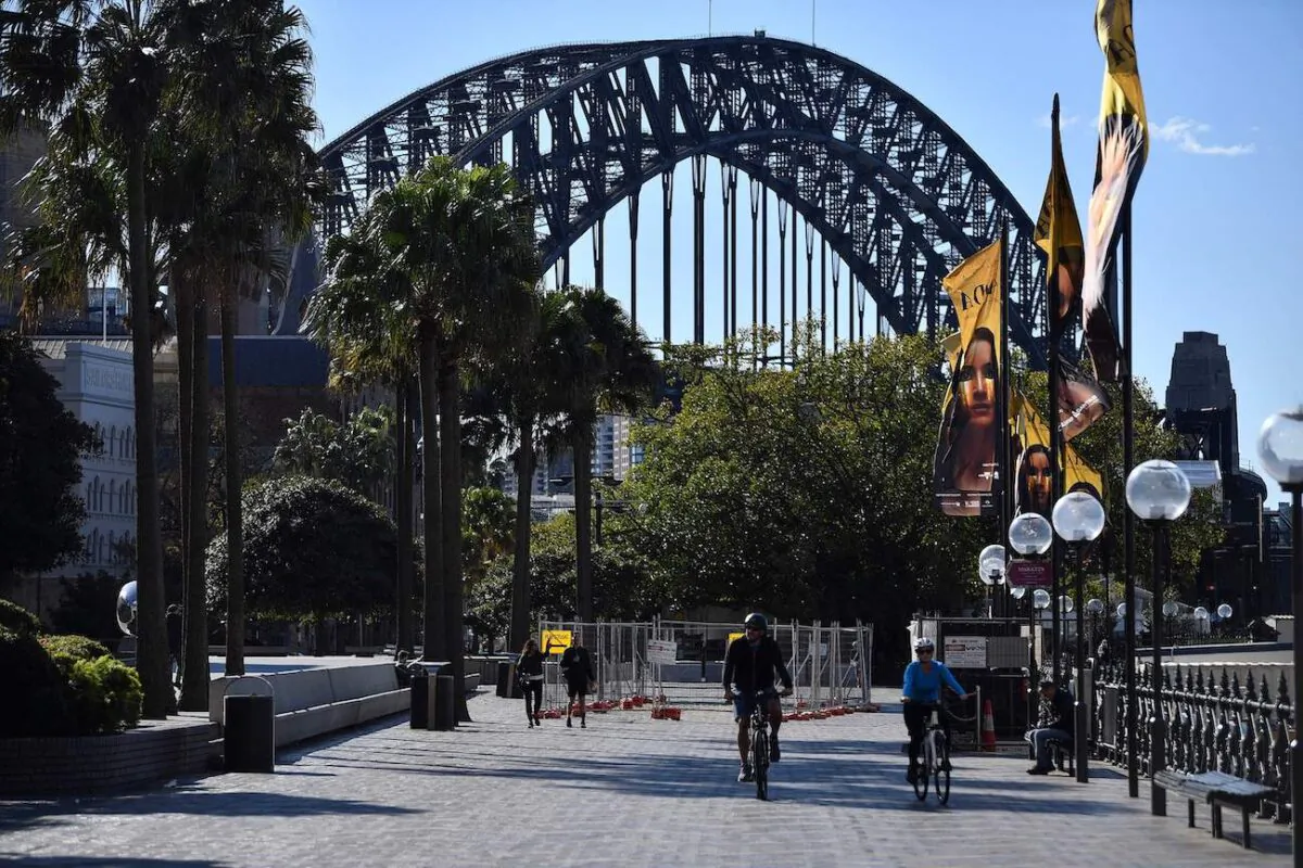 A couple ride along the harbour in Sydney on June 26, 2021, as Australia's largest city entered a two-week lockdown to contain an outbreak of the highly contagious Delta variant. (Saeed Khan/AFP via Getty Images)