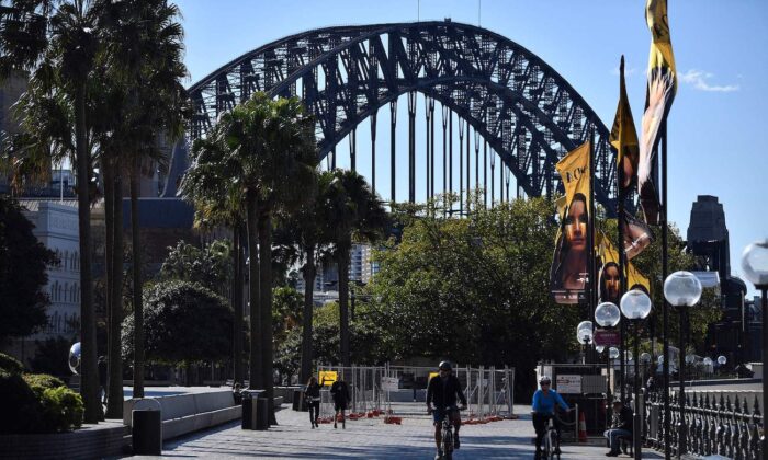 A couple ride along the harbour in Sydney on June 26, 2021, as Australia's largest city entered a two-week lockdown to contain an outbreak of the highly contagious Delta variant. (Saeed Khan/AFP via Getty Images)