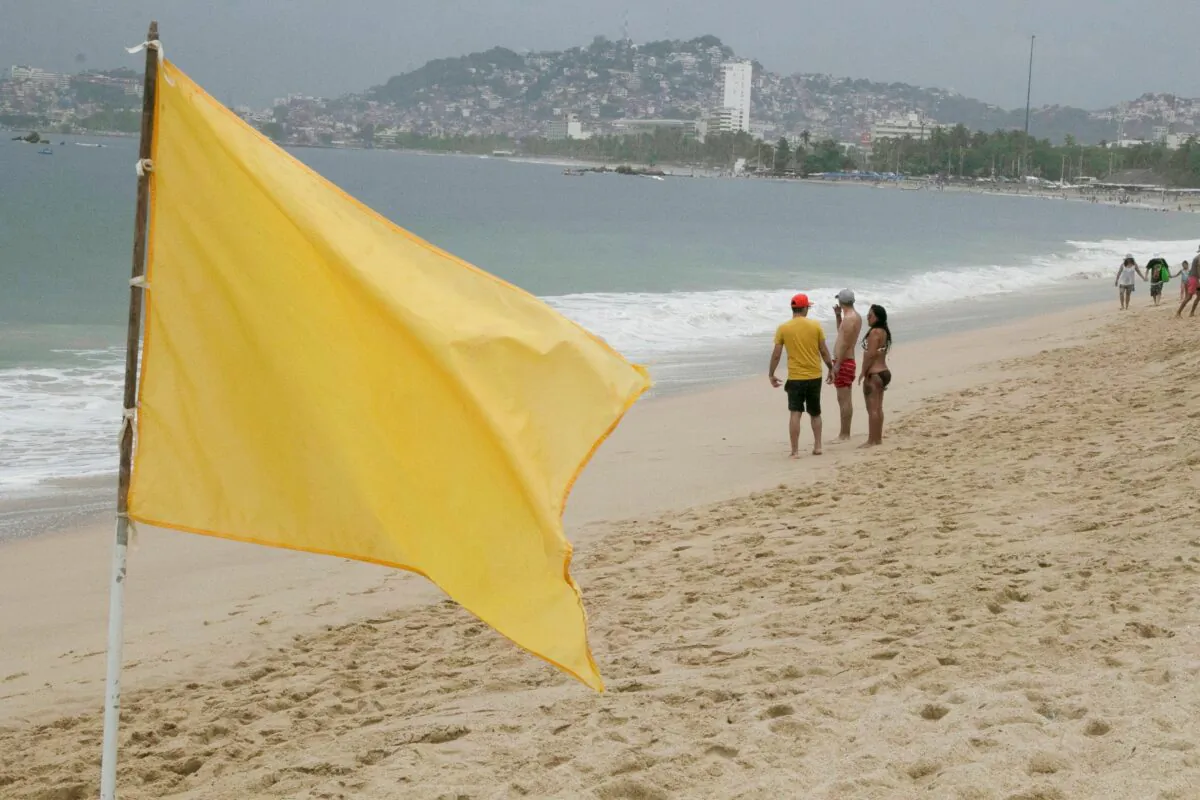 Tourists are pictured on Acapulco beach after storm Enrique became a hurricane off the coast of western Mexico, in Acapulco, Mexico, on June 26, 2021. (Javier Verdin/Reuters)