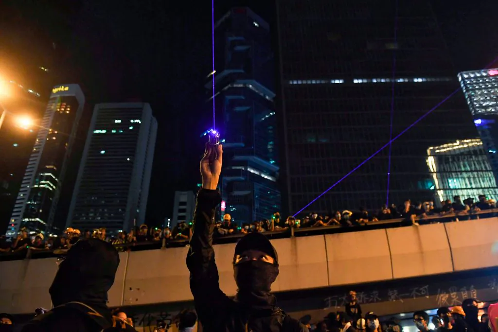 Anti-extradition bill protesters point laser beams outside of the Legislative Council in Hong Kong on Aug. 18, 2019. (LILLIAN SUWANRUMPHA/AFP via Getty Images)