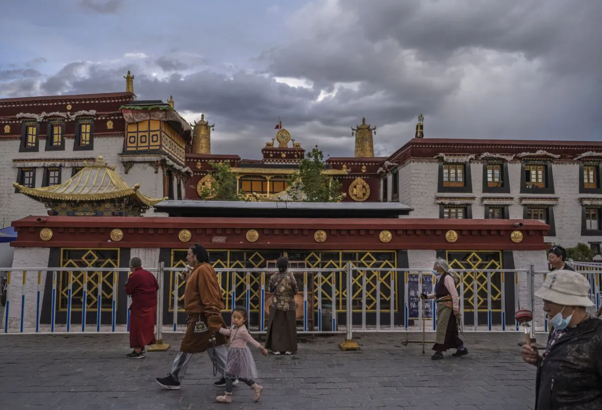 Tibetan Buddhists walk the kora in front of the Jokhang Temple, a UNESCO heritage site, on June 1, 2021 in Lhasa, Tibet region, China. Travel restrictions for foreign travelers were recently loosened in a bid to boost tourism to Tibet. The Chinese regime is aiming for 61 million visitors annually by 2025, more than 15 times the number of Tibets inhabitants. (Kevin Frayer/Getty Images)