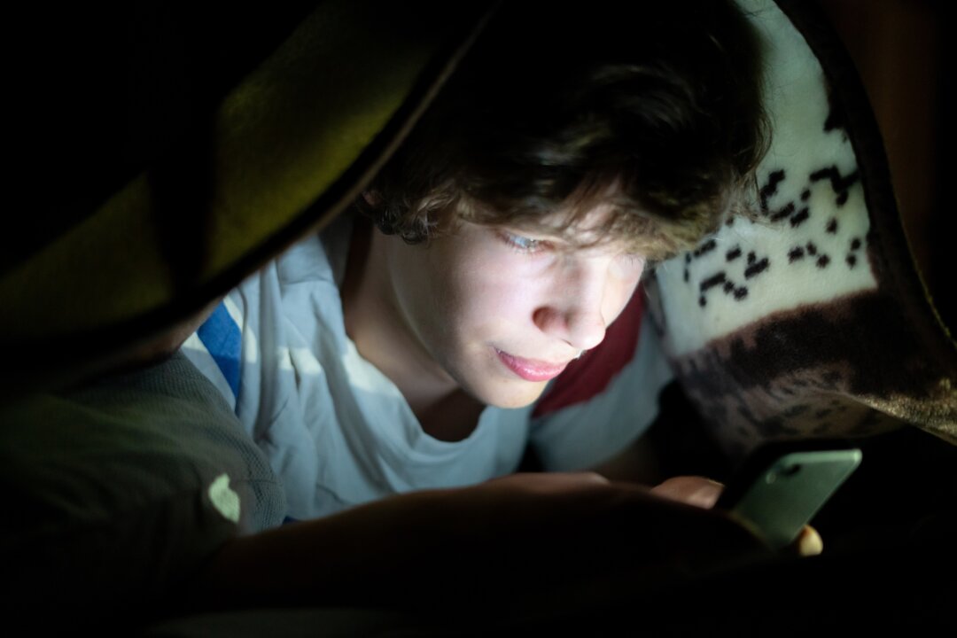 Bedtime media use leads to poor sleep, which in turn leads to more bedtime media use. (Mike_shots/Shutterstock)