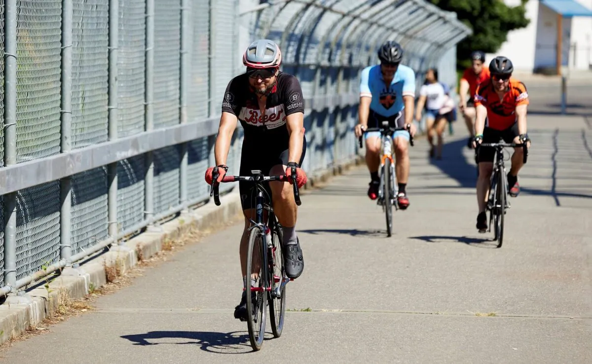 Bicyclists ride across a pedestrian bridge in the morning to escape from the heat in Portland, Ore., on June 27, 2021. (Craig Mitchelldyer/AP Photo)