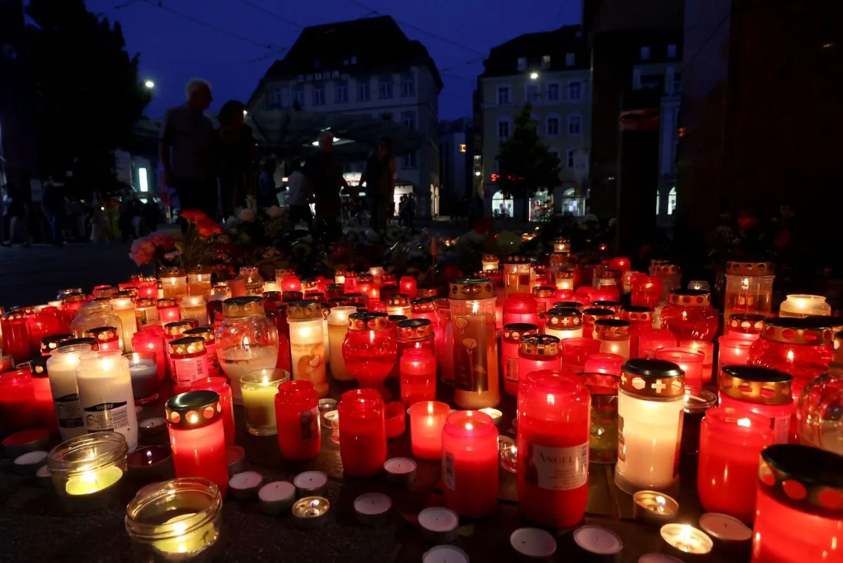 Flowers and candles in front of a closed and cordoned off department store in the city centre of Wuerzburg, Germany, on June 26, 2021. (Karl-Josef Hildenbrand/dpa via AP)
