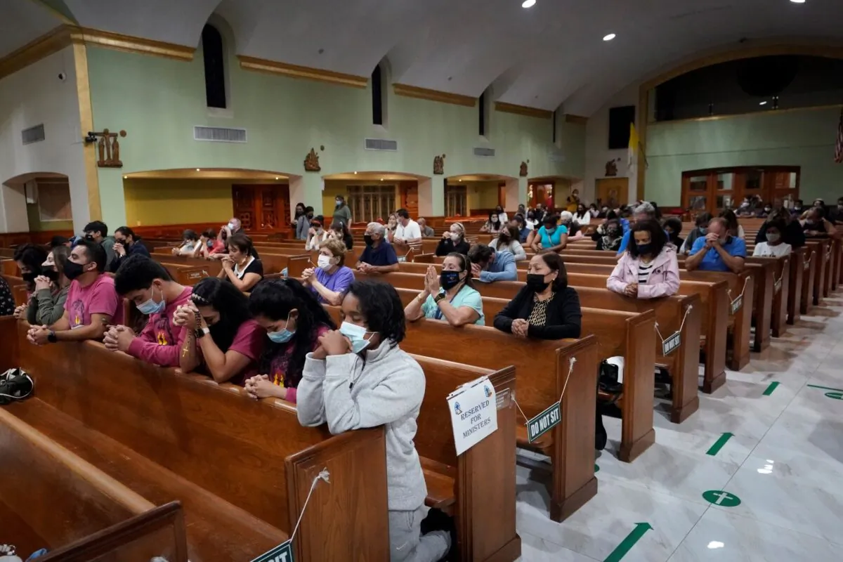 People pray during a prayer vigil for the victims and families of the Champlain Towers collapsed building in Surfside, Fla., at the nearby St. Joseph Catholic Church in Miami Beach, Fla., on June 26, 2021. (Wilfredo Lee/AP Photo)