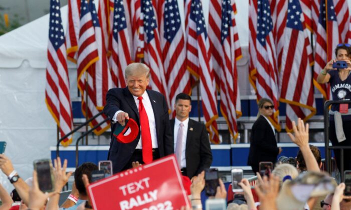 Former president Donald Trump points at individuals and throws hats into the crowd as he arrives for his campaign-style rally in Wellington, Ohio, on June 26, 2021. (Stephen Zenner/AFP via Getty Images)