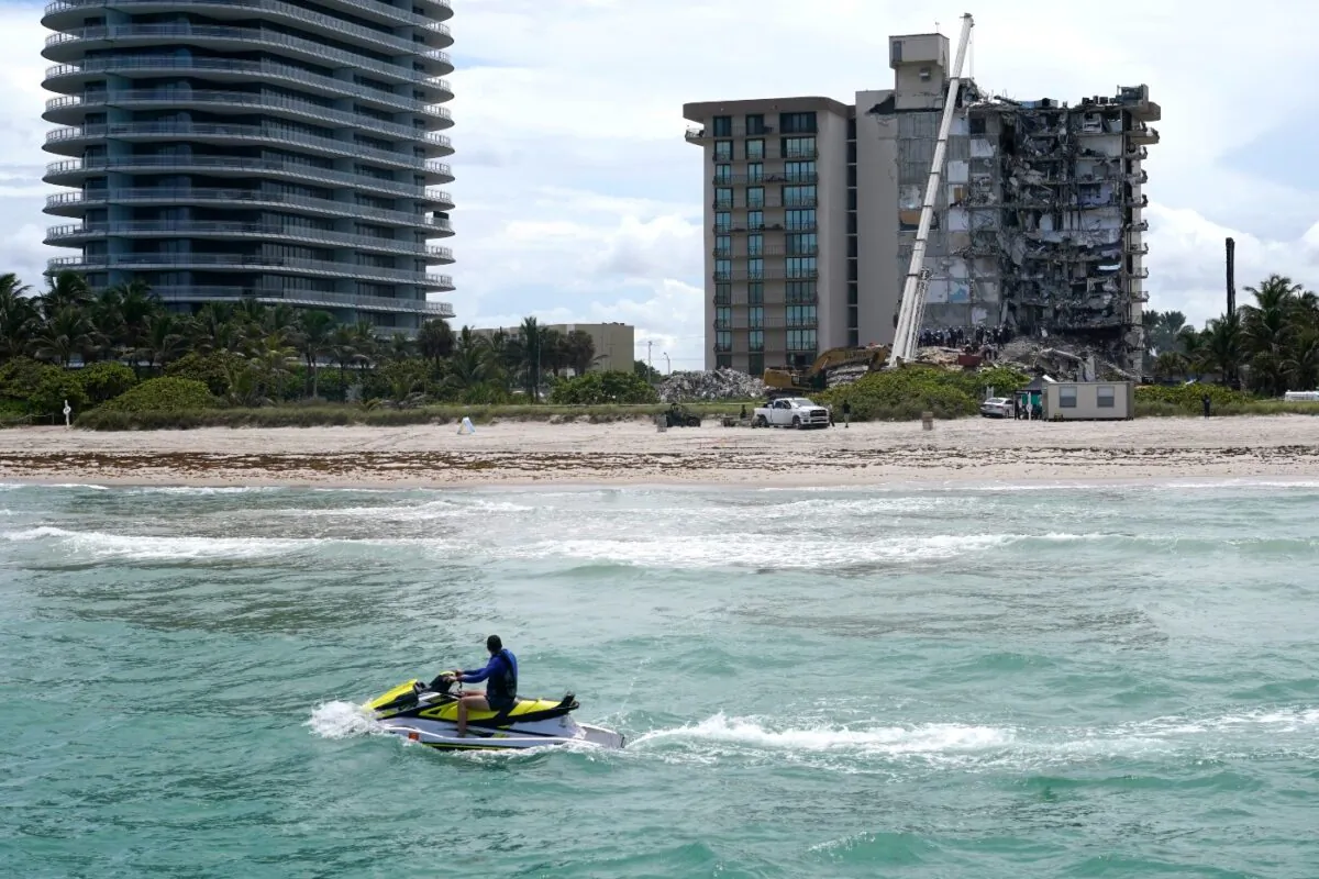 A jet ski rides by as rescue workers search in the rubble for survivors at the Champlain Towers South condominium, in the Surfside area of Miami, Fla., on June 26, 2021. (Lynne Sladky/AP Photo)