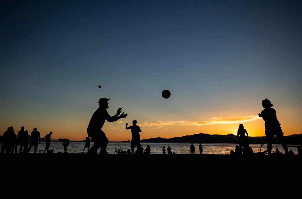 People are silhouetted while playing and gathering at English Bay Beach at sunset, in Vancouver, B.C., on June 21, 2021. A heat warning is in effect for most of Western Canada and the weather agency says numerous daily temperature records have been shattered across B.C. (The Canadian Press/Darryl Dyck )