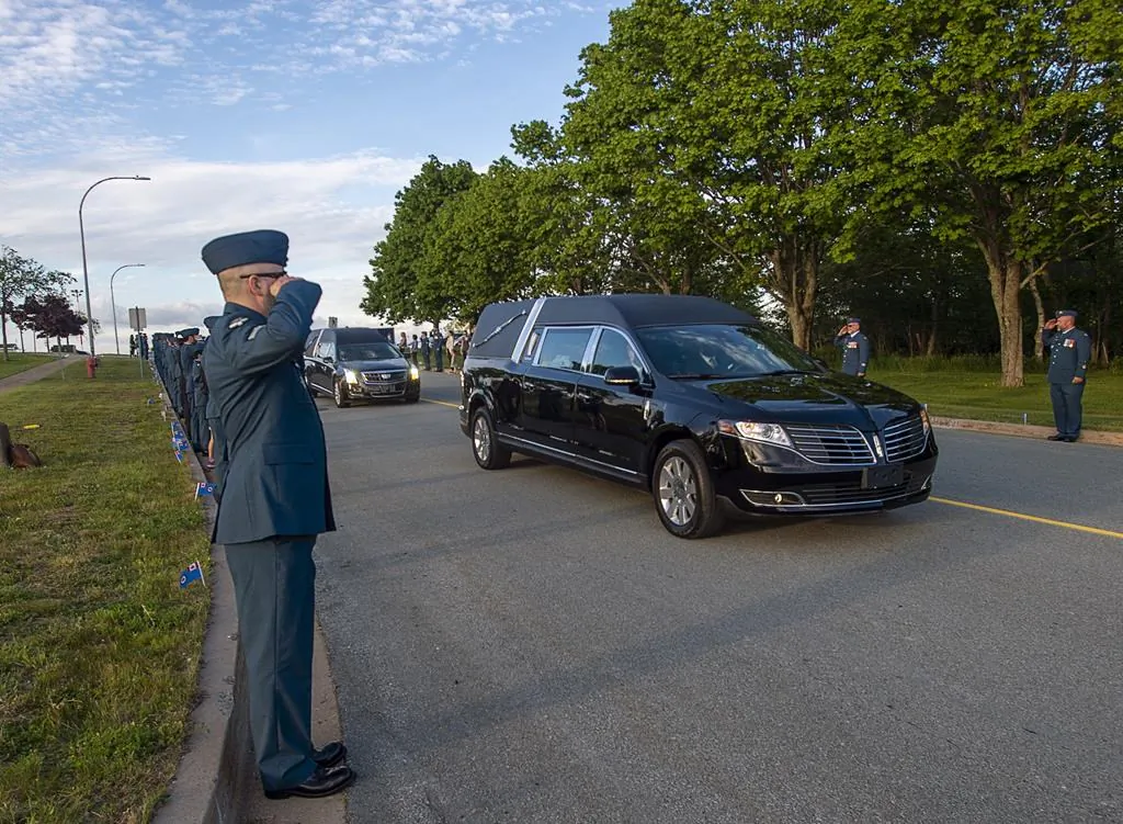 Military personnel salute as the homecoming motorcade procession for the return of Capt. Brenden MacDonald, Capt. Maxime Miron-Morin and Master Cpl. Matthew Cousins, drives through 12 Wing Shearwater near Dartmouth, N.S. on June 25, 2020. Six Canadian Armed Forces  members died when a CH-148 Cyclone helicopter flying from the Halifax-class frigate HMCS Fredericton crashed off the coast of Greece while taking part in a NATO exercise in the Mediterranean. (The Canadian Press/Andrew Vaughan)