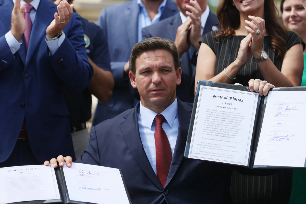 Florida Gov. Ron DeSantis holds up two bills he signed at the Florida National Guard Robert A. Ballard Armory in Miami, Florida on June 07, 2021. (Joe Raedle/Getty Images)