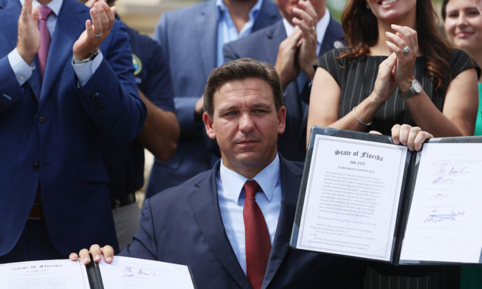 Florida Gov. Ron DeSantis holds up two bills he signed at the Florida National Guard Robert A. Ballard Armory in Miami, Florida on June 07, 2021. (Joe Raedle/Getty Images)