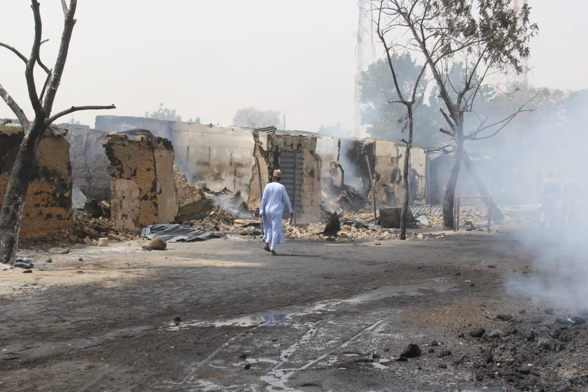 A man walks past shops burned down by suspected members of the Islamic State West Africa Province (ISWAP) during an attack, in the village of Auno, Nigeria, on Feb. 9, 2020. (Audu Marte/AFP via Getty Images)