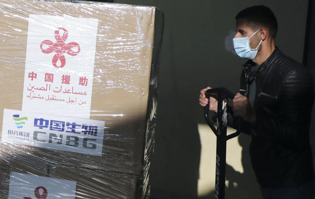 A Palestinian worker unloads a shipment of the Sinopharm COVID-19 vaccines donated by Beijing in the West Bank city of Nablus, on March 29, 2021. (Jaafar Ashtiyeh/AFP via Getty Images)