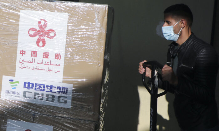 A Palestinian worker unloads a shipment of the Sinopharm COVID-19 vaccines donated by Beijing in the West Bank city of Nablus, on March 29, 2021. (Jaafar Ashtiyeh/AFP via Getty Images)