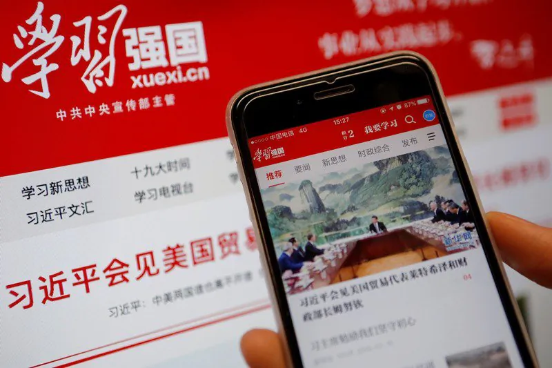 Chinese communist propaganda app Xuexi Qiangguo, which literally translates as 'Study to make China strong,' is seen on a mobile phone in front of its website on a computer in this illustration picture taken February 18, 2019. (Tingshu Wang/Reuters)