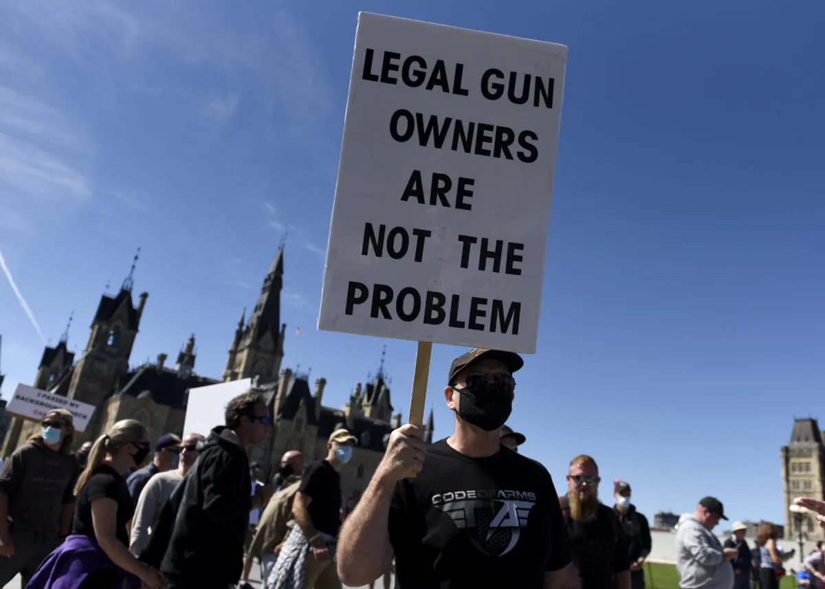A gun owner holds a sign as they participate in a rally organized by the Canadian Coalition for Firearm Rights against the government's new gun regulations, on Parliament Hill in Ottawa, on Sept. 12, 2020. (The Canadian Press/Justin Tang)