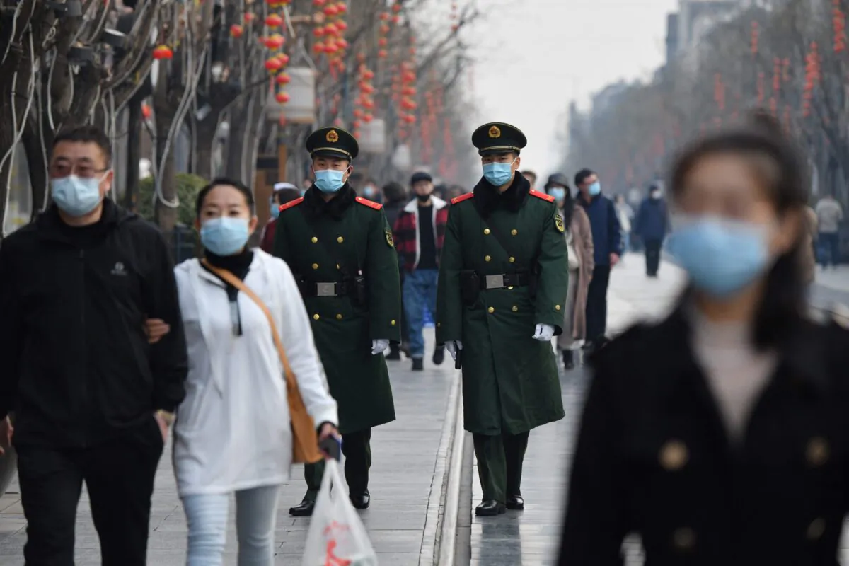 Two paramilitary police officers patrol in the area south of the Great Hall of the People during the second plenary session of the National People's Congress in Beijing on March 8, 2021. (Greg Baker/AFP via Getty Images)