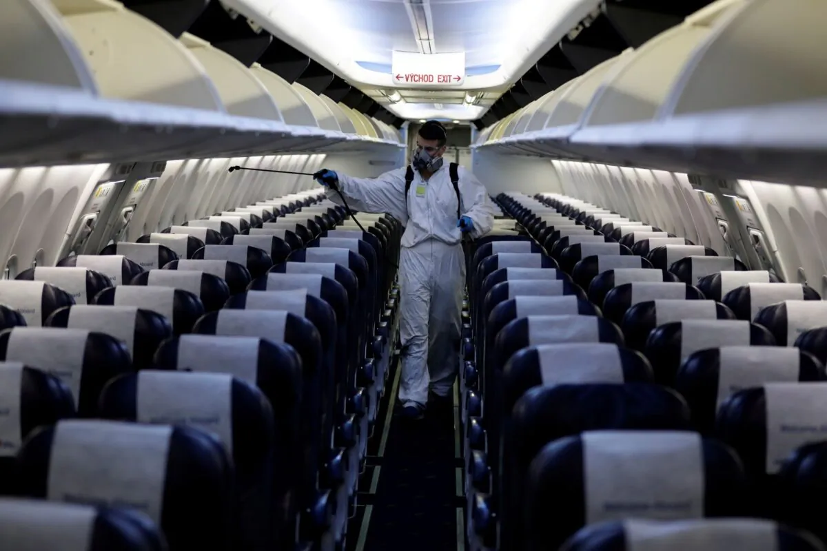 A worker in a protective suit disinfects a passenger plane of Smartwings airline at Vaclav Havel Airport in Prague, Czech Republic, on May 21, 2020. (David W Cerny/Reuters)