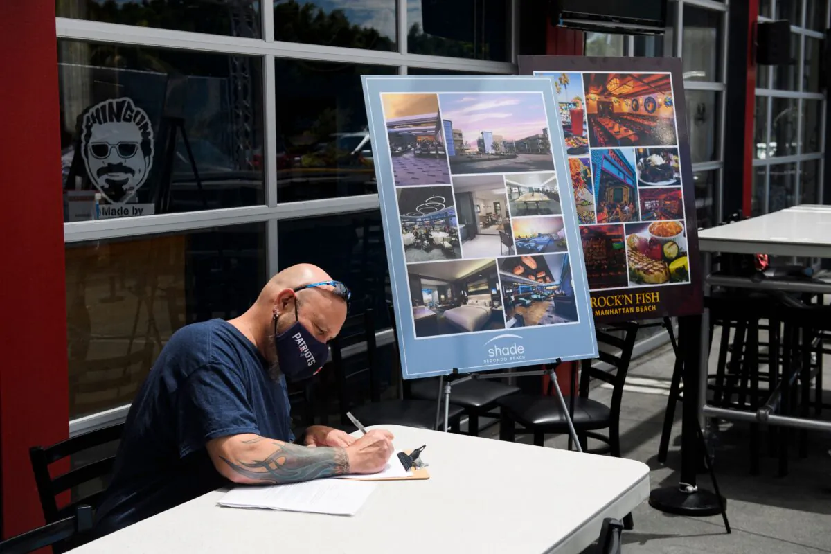 A man completes a job application before interviewing and later being hired for a job on the spot as a line cook during a job fair in Torrance, Calif. on June 23, 2021. (Patrick T. Fallon/AFP via Getty Images)