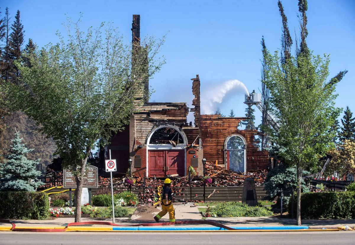 St. John Baptiste Parish Catholic church, as firefighters put out hot spots, in Morinville, Alberta, on June 30, 2021. (Jason Franson/The Canadian Press)