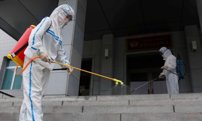 Staff of the Pyongyang Primary School No. 4 spray disinfectant in Pyongyang, North Korea, on June 30, 2021. (Jon Chol Jin/AP Photo)