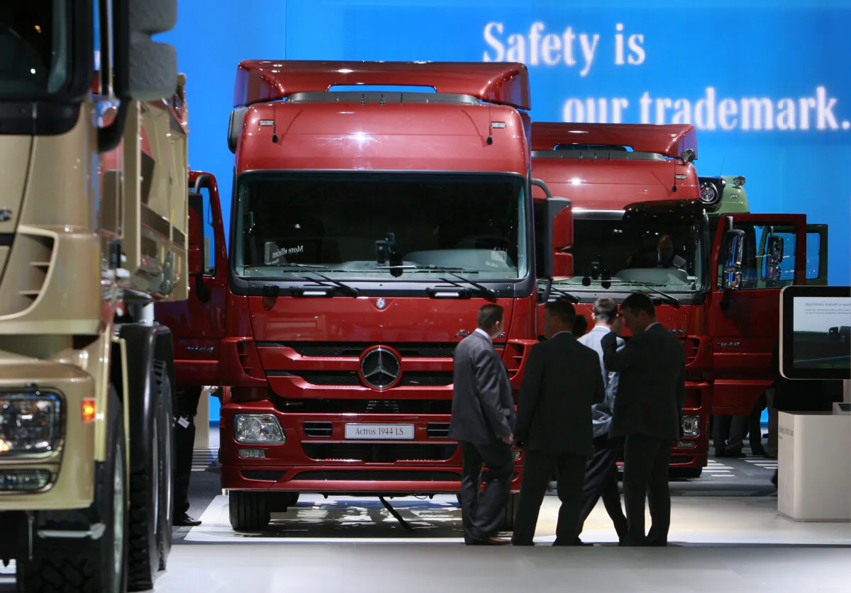 Visitors stand in front of a display of heavy trucks at the entrance to the Daimler exhibition area during a preview day at the IAA commercial vehicles trade fair in Hanover, Germany, in a file photo. (Christian Charisius/Files/Reuters)