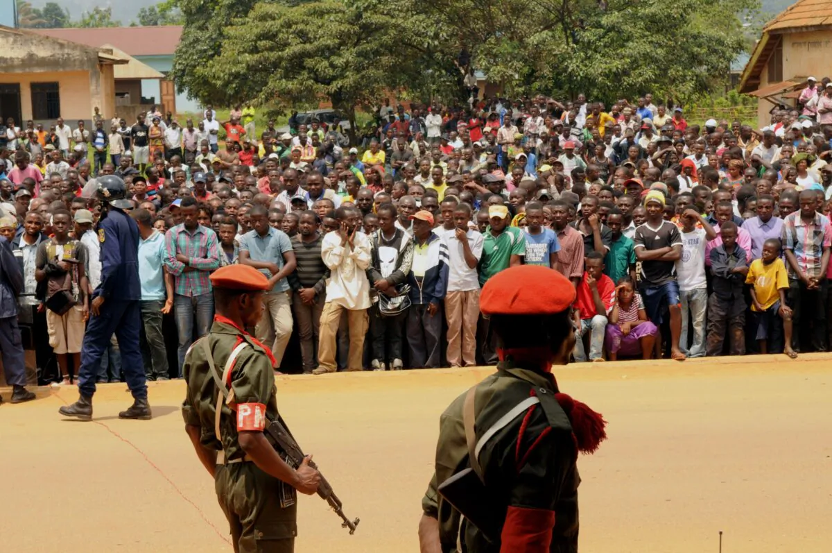 Servicemen of the Armed Forces of the Democratic Republic of Congo stand guard as people gathered to attend the public hearing of suspected members of the Allied Democratic Forces, a terrorist group, in Beni on Aug. 20, 2016. (Kudra Maliro/AFP via Getty Images)