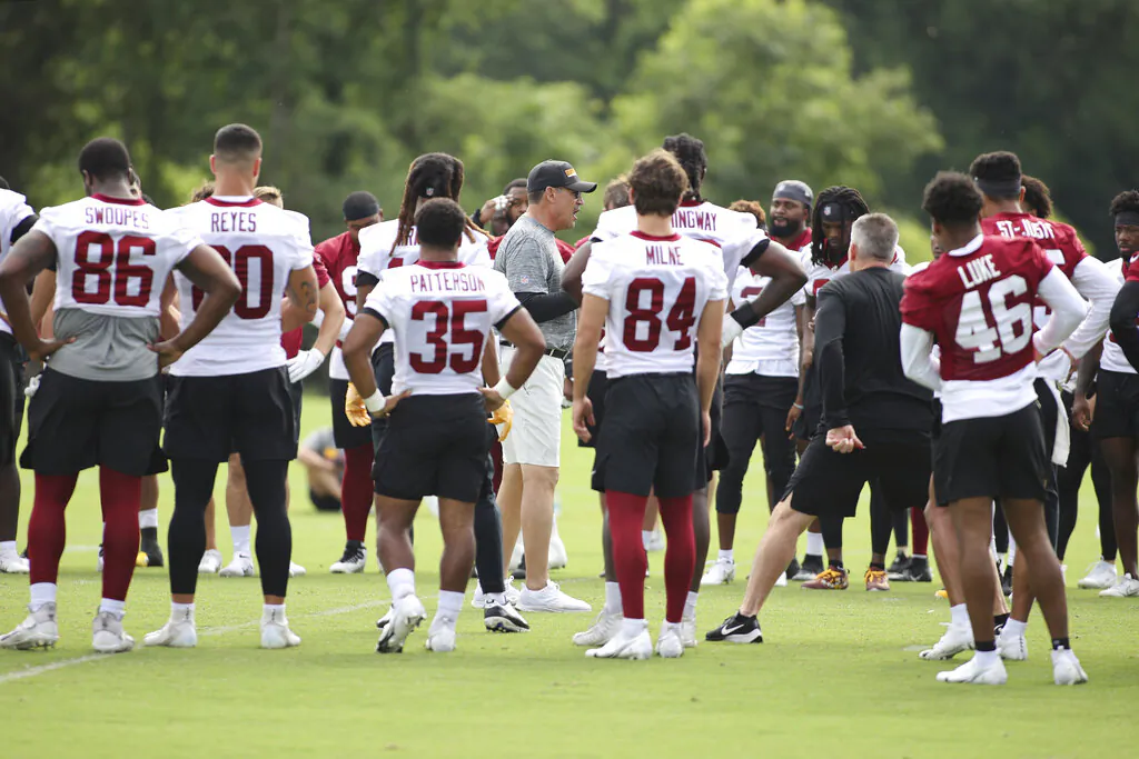 Washington Football Team head coach Ron Rivera, center, talks to his players during an NFL football practice at Inova Sports Performance Center in Ashburn, Va., on June 10, 2021. (Luis M. Alvarez/AP Photo)