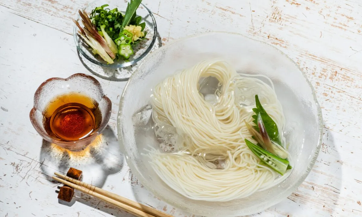 Bundles of chilled somen are typically served on a family-style platter, with individual bowls of tsuyu for dipping and a variety of accoutrements for topping. (norikko/Shutterstock)