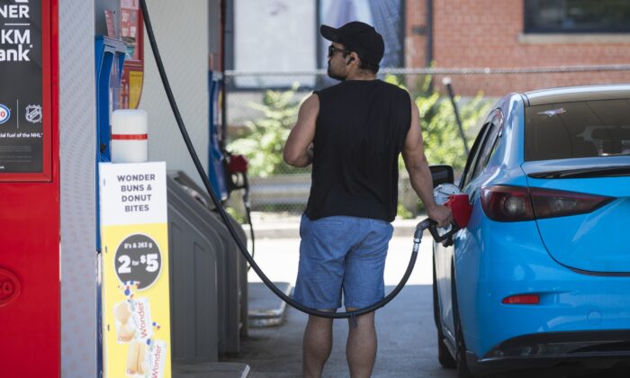 A commuter pumps gas into their vehicle at a Esso gas station in Toronto, Canada, on June 15, 2021. (The Canadian Press/Tijana Martin)