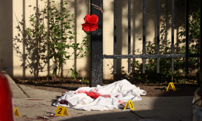 A blood-soaked sheet sits among evidence markers following a shooting where three people were shot at the Wentworth Gardens housing complex in the Bridgeport neighborhood in Chicago, Illinois, on June 23, 2021. (Scott Olson/Getty Images)
