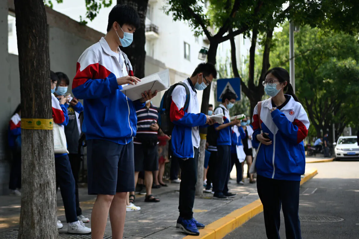 Mask-clad students conduct last-minute studying before sitting for the second day of the National College Entrance Examination (NCEE), known as "gaokao", in Beijing on July 8, 2020.
According to “China’s 2020 Fertility Report” published by the Evergrande Research Institute, on average, education was 32.44 percent of the total expenditure for Chinese families in 2020, showing a rising trend.
(Photo by WANG ZHAO/AFP via Getty Images)