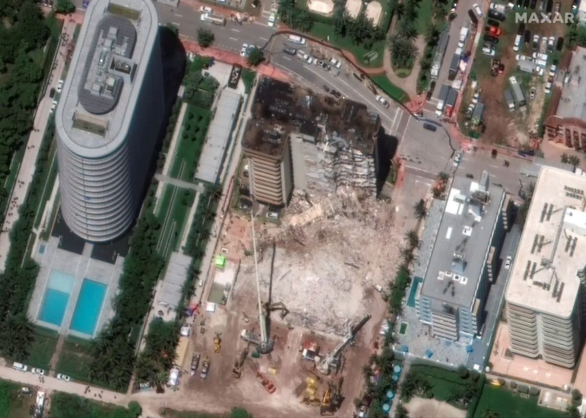 Heavy-lift cranes are used to aid in the search and recovery operation at the partially collapsed Champlain Towers South condo building in Surfside, Fla., on July 3, 2021. (Maxar Technologies via AP)