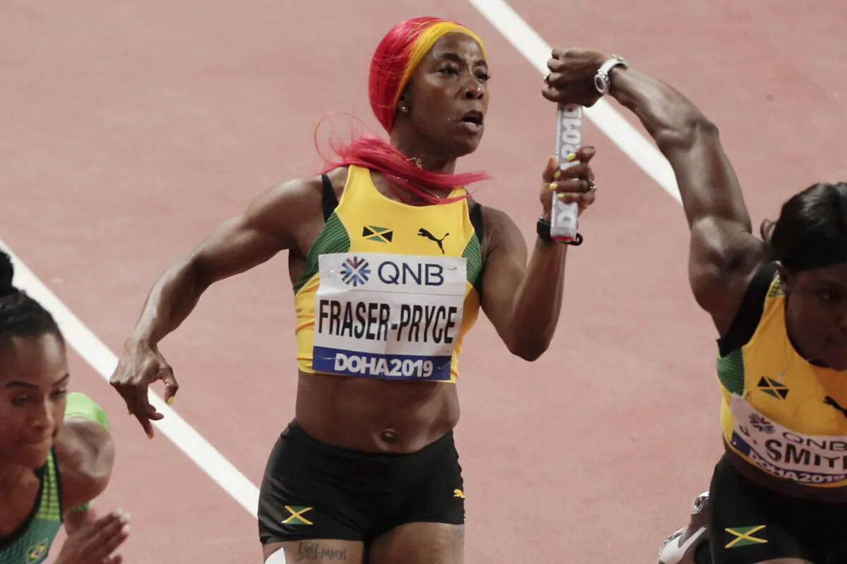 Jamaica's Shelly-Ann Fraser-Pryce, center, hands off to Jonielle Smith, right, during a women's 4x100 meter relay semifinal at the World Athletics Championships in Doha, Qatar, on Oct. 4, 2019. (Nariman El-Mofty/AP Photo)