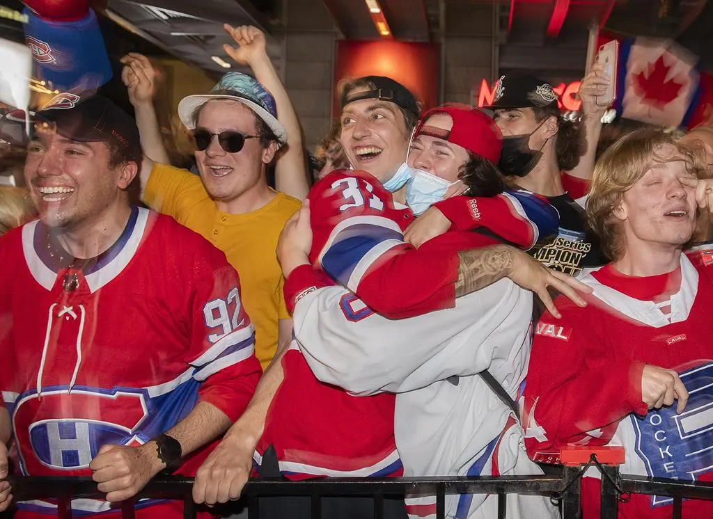 Montreal Canadiens fans celebrate after Canadiens' Josh Anderson, not shown, scored the game-winning goal during overtime Game 4 Stanley Cup finals action against the Tampa Bay Lightning, in Montreal, on July 5, 2021. (The Canadian Press/Ryan Remiorz)