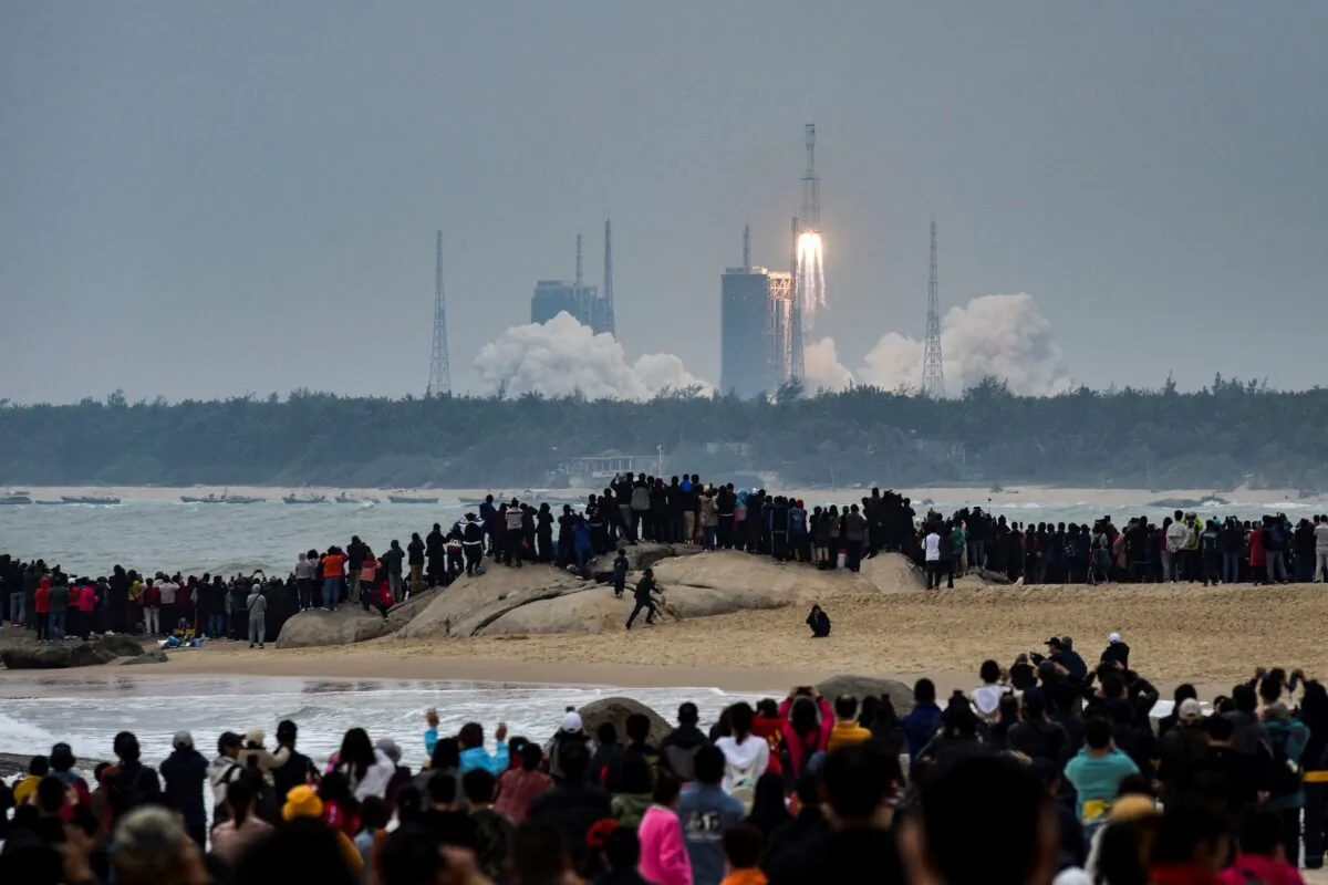 People watch a Long March-8 rocket, the latest China's Long March launch vehicle fleet, as it lifts off from the Wenchang Space Launch Center in Hainan Province, China, on Dec. 22, 2020. (AFP via Getty Images)