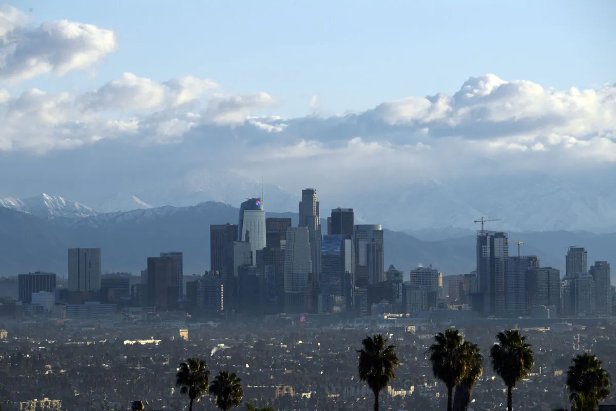 Snow-topped mountains stand behind the Los Angeles downtown skyline after sunrise in Los Angeles on Dec. 29, 2020. (Patrick T. Fallon/AFP via Getty Images)
