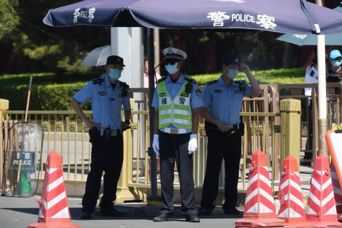 Police officers keep watch on a road near Tiananmen Square in Beijing, China on June 4, 2021. (Greg Baker/AFP via Getty Images)