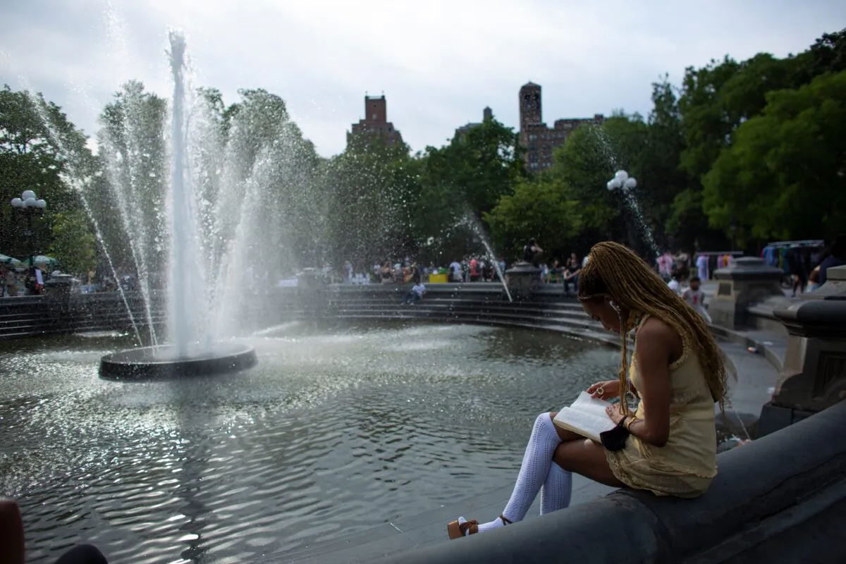 A woman reads near the fountain in Washington Square Park in New York on June 18 2021. (Kena Betancur/AFP via Getty Images)