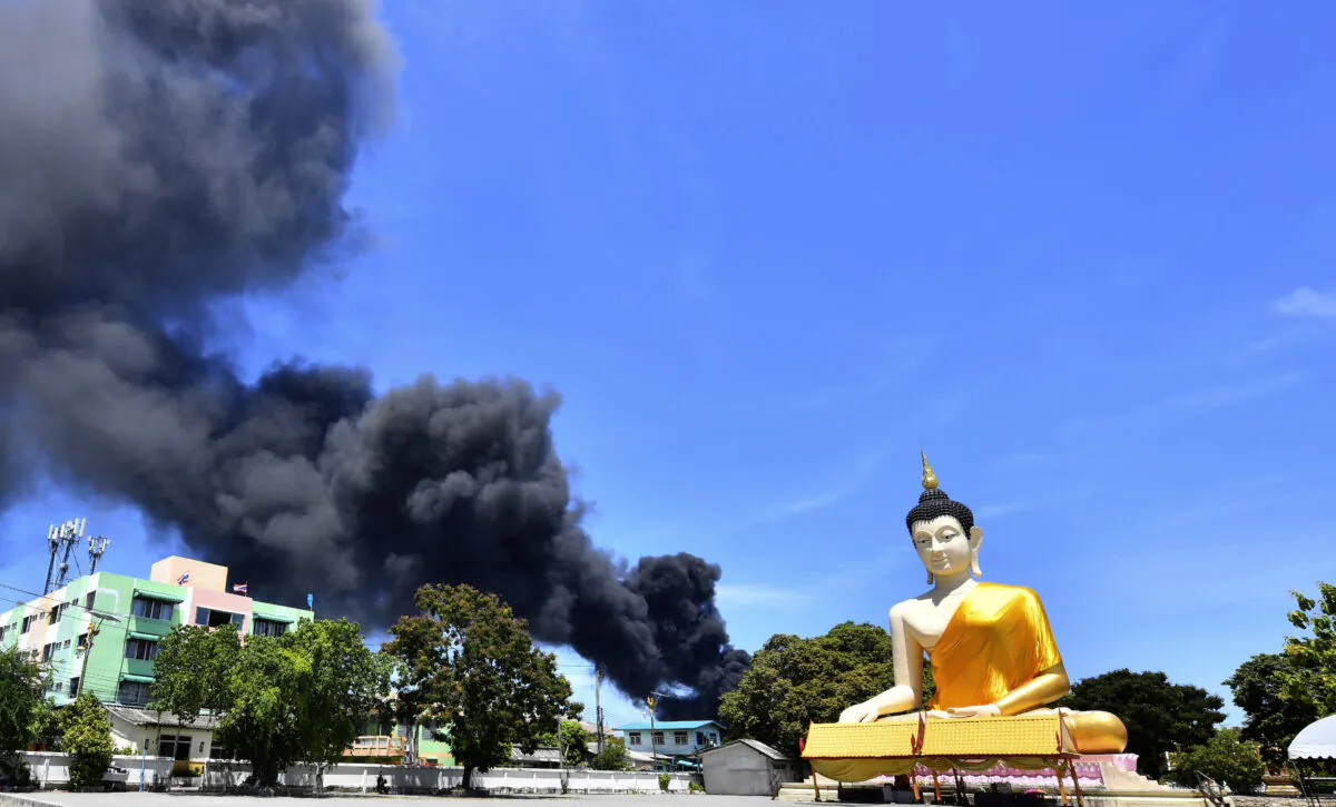 Rising smoke is seen behind the giant Buddha statue in Samut Prakan province, Thailand, on July 5, 2021. (AP Photo)