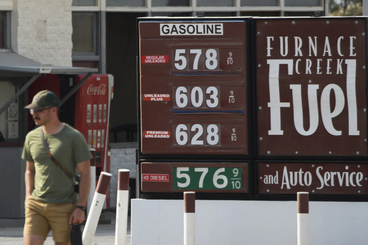 A pedestrian walks past gas station fuel prices above $5 and $6 per gallon at Death Valley National Park in Furnace Creek, Calif., on June 17, 2021. (Patrick T. Fallon/AFP via Getty Images)