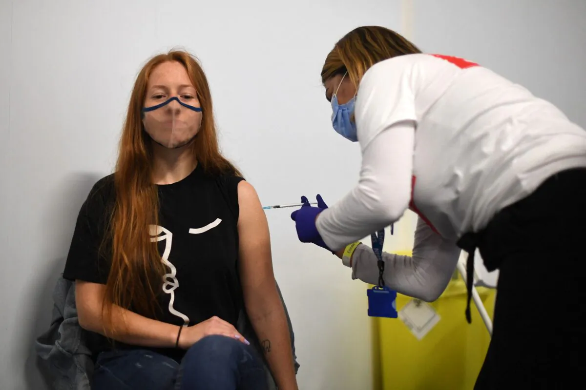Members of the public receive a dose of a COVID-19 Pfizer vaccine inside a temporary vaccination center set up at the Emirates Stadium, home to the Arsenal football club, in north London on June 25, 2021. (Daniel Leal-Olivas/AFP via Getty Images)