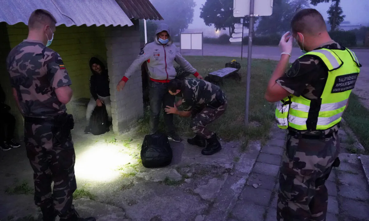 Lithuanian border guards detain migrants on Lithuania-Belarus border in Kalviai, Lithuania, on July 7, 2021. (Janis Laizans/Reuters)