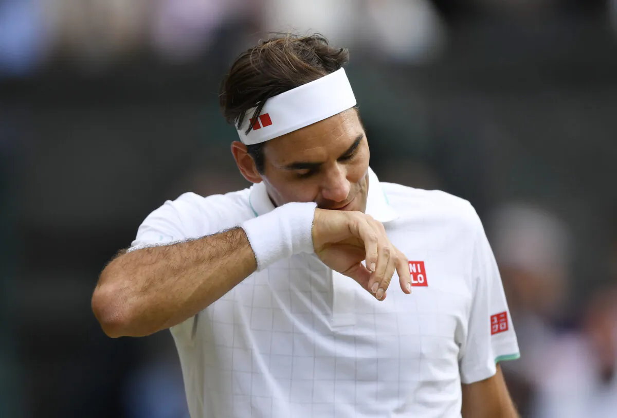 Switzerland's Roger Federer wipes his face during his quarter final match against Poland's Hubert Hurkacz at the Wimbledon Tennis Championships in London, UK, on July 7, 2021. (Toby Melville/Reuters)