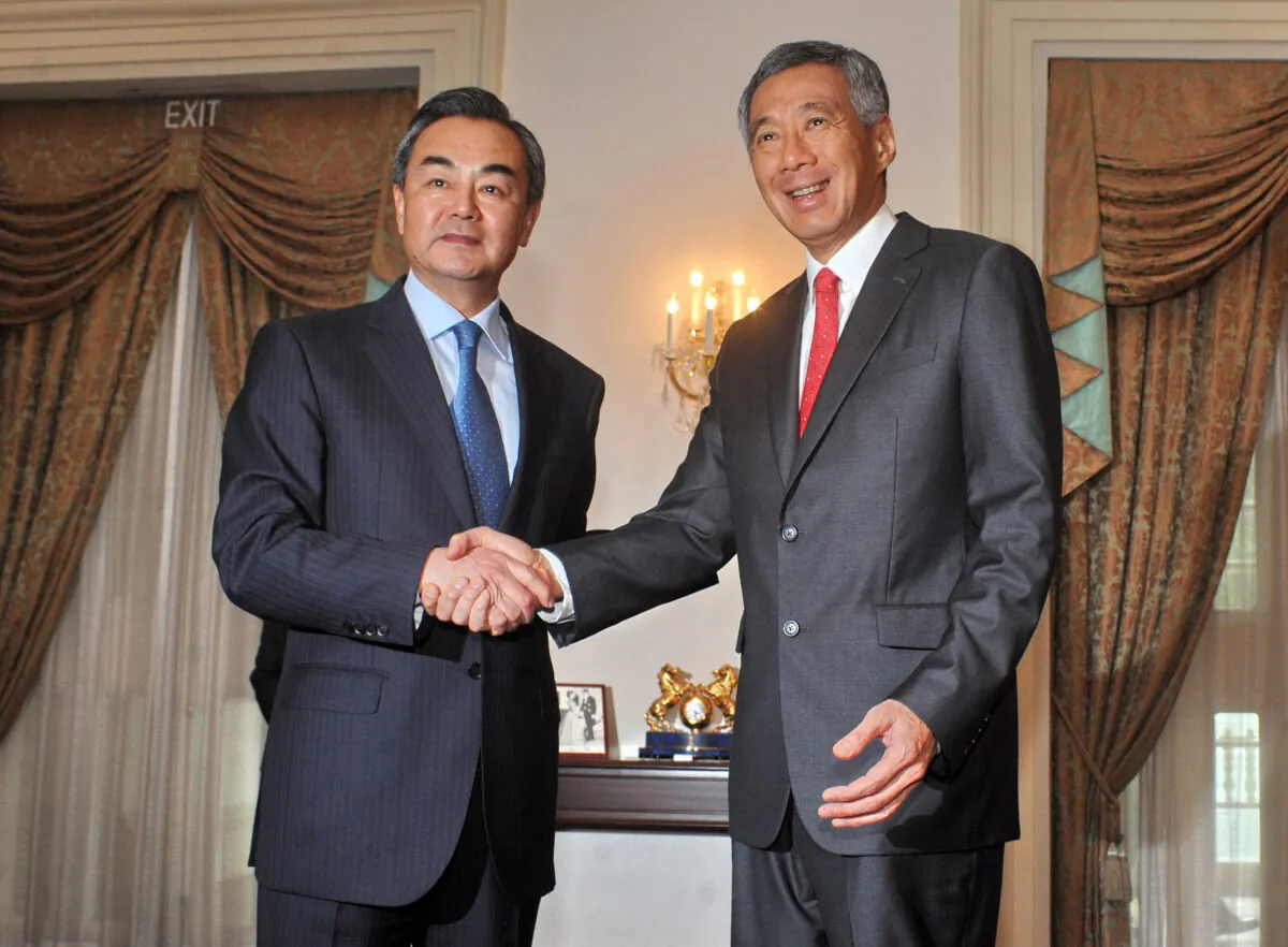 Chinese Foreign Minister Wang Yi (L) shakes hands with Singaporean Prime Minister Lee Hsien Loong (R) during a call at the Istana presidential palace in Singapore on May 3, 2013. Wang is on a two-day visit in Singapore, his first official visit as foreign minister. (Mohd Fyrol/AFP via Getty Images)