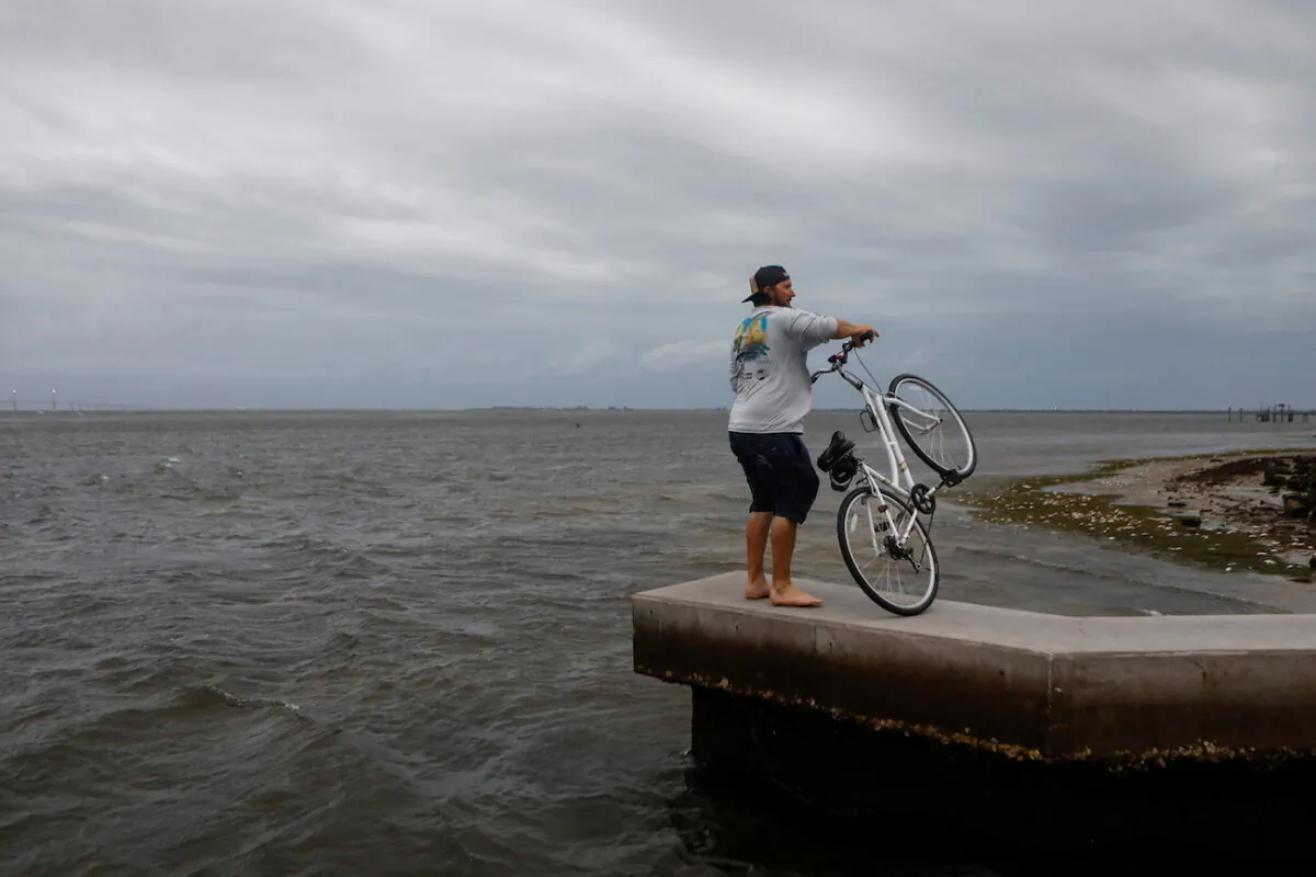 A man holds his bicycle at Bay Vista Park, as Elsa strengthened into a Category 1 hurricane hours before an expected landfall on Florida's northern Gulf Coast, in St. Petersburg, Florida, on July 6, 2021. (Octavio Jones/Reuters)