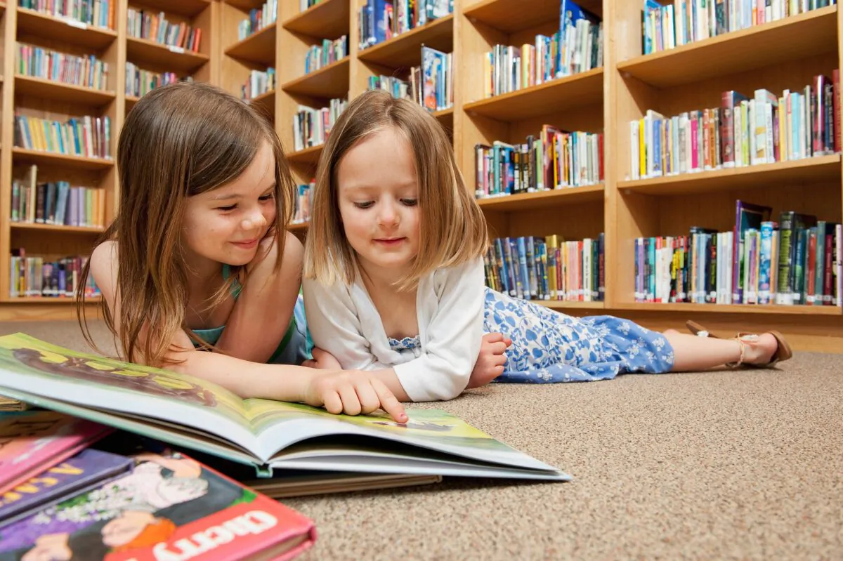 Two girls reading a book. (qiangxuer/Pixabay)